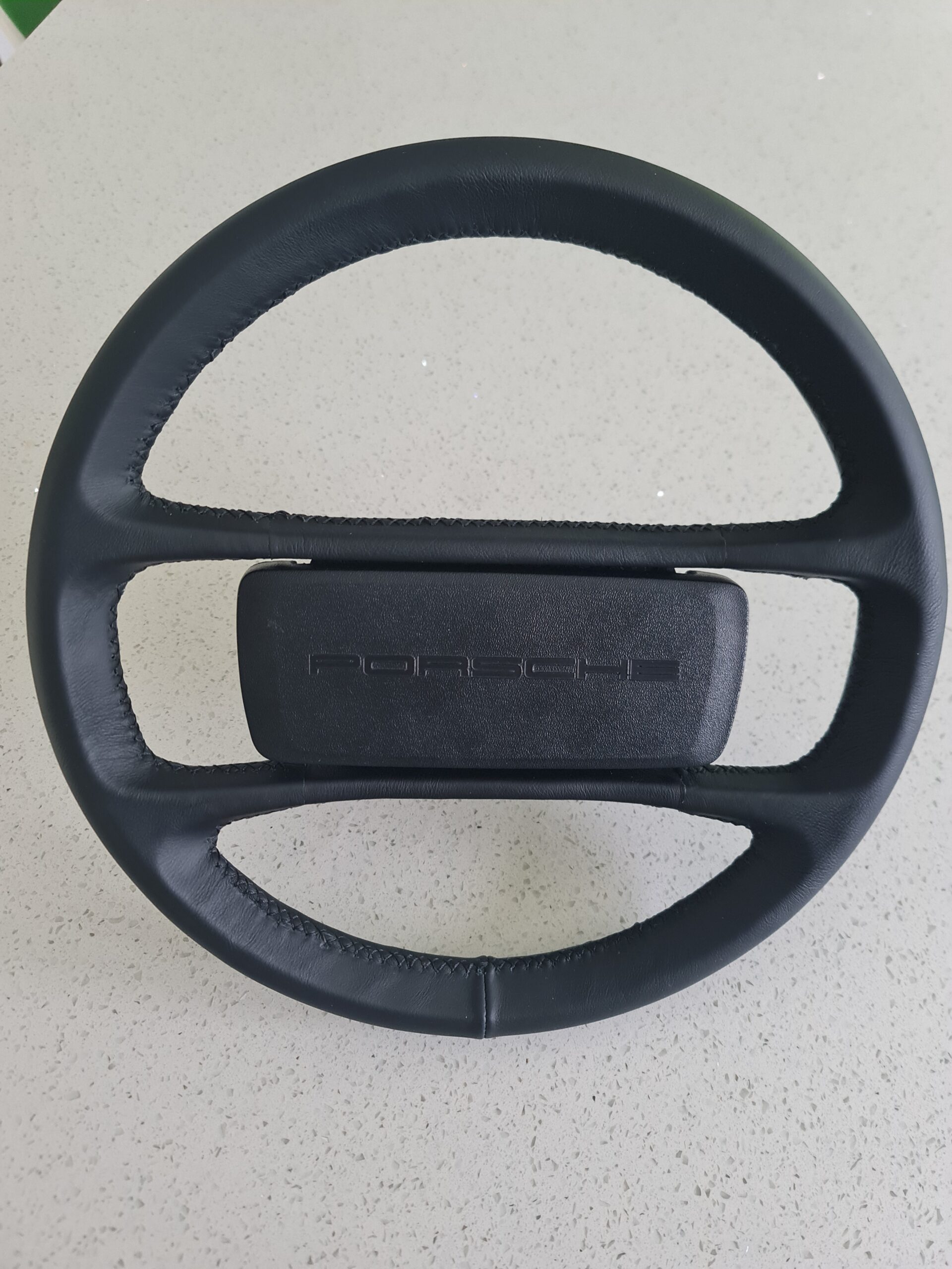 Fully restored Porsche steering wheel with fresh black leather.