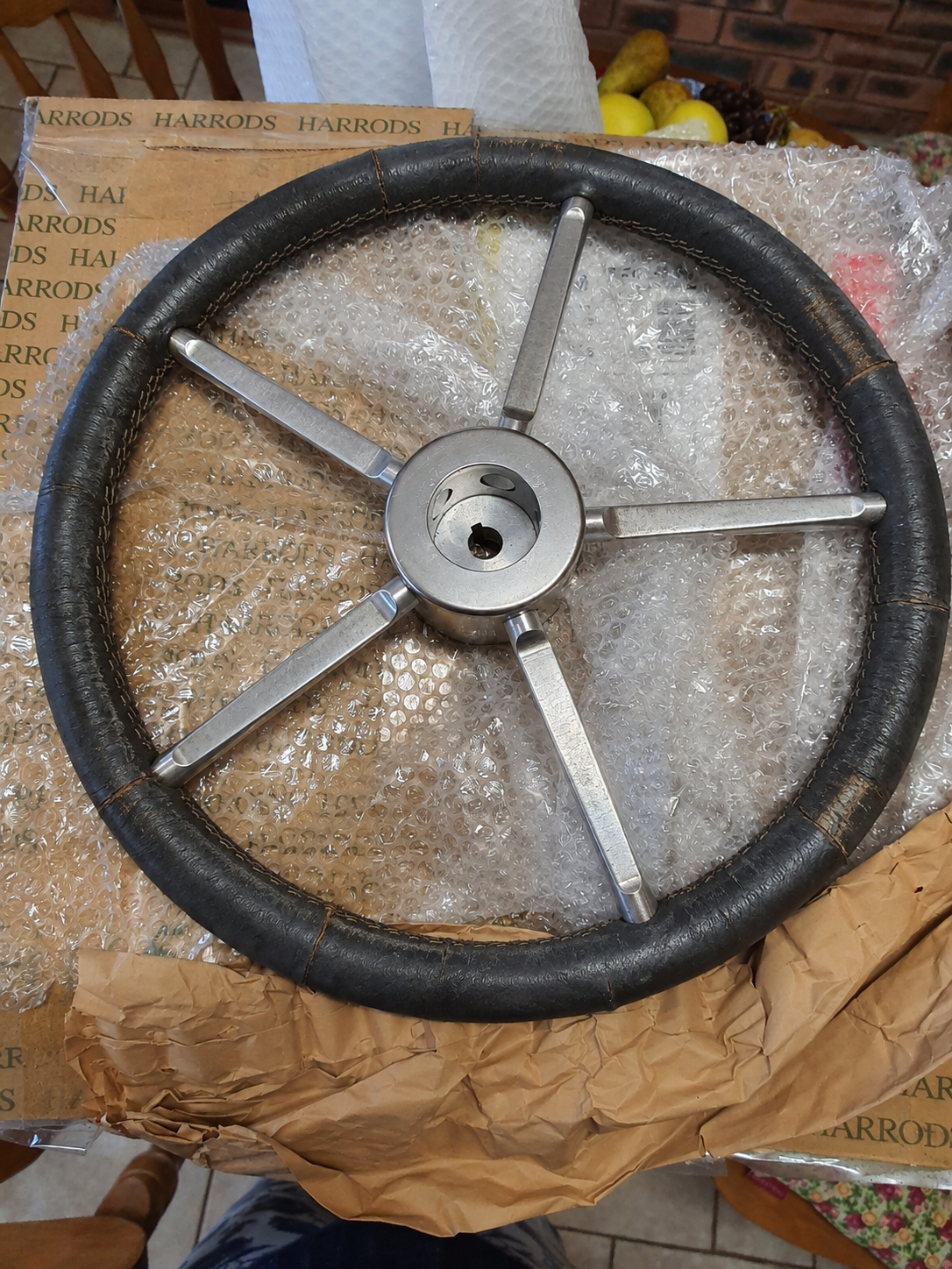 Old, weathered marine steering wheel before upholstery repair at Pride Car Customs.