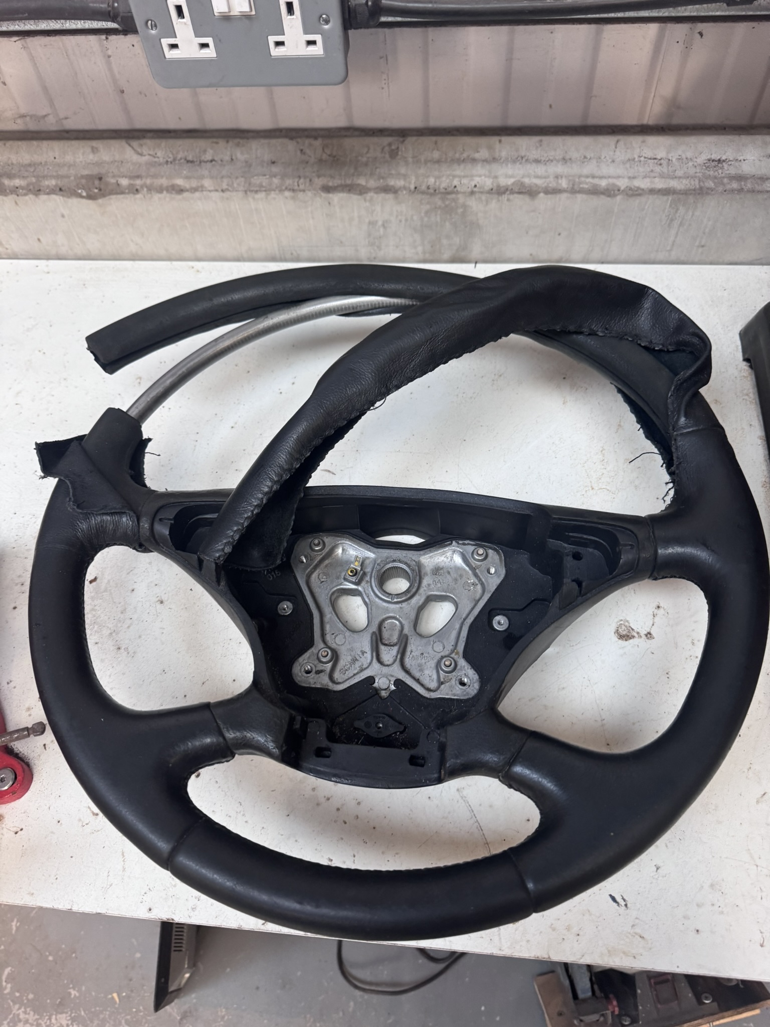 Heavily worn and faded Scania truck steering wheel before leather refurbishment.