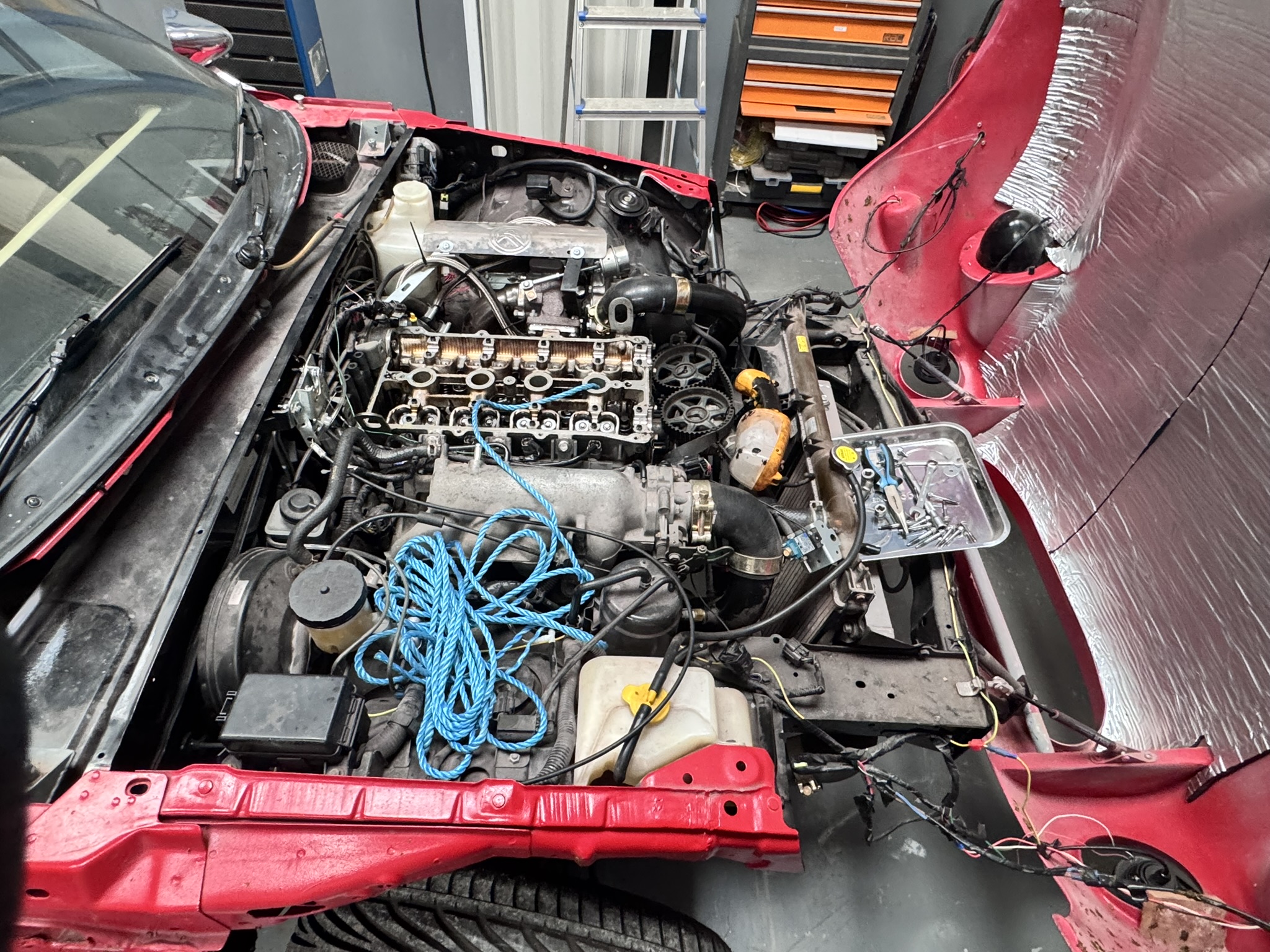 1993 Mazda MX-5 1.8 engine bay undergoing mechanical restoration and maintenance at Pride Car Customs Image caption